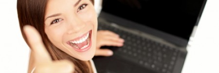 Laptop woman happy giving thumbs up success sign sitting at computer PC with excited face expression